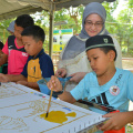 Salah seorang kakitangan MAIK melihat hasil mewarna batik oleh anak-anak asnaf