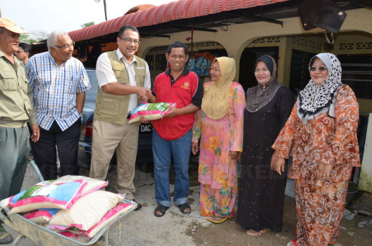 Tuan Pengarah, Haji Zahari B. Ibrahim Mengagihkan Beras Kepada Penduduk Kampung